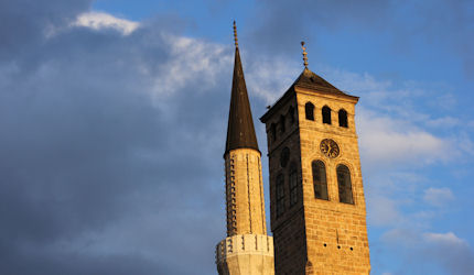 A minaret and clock tower in Old Town Sarajevo